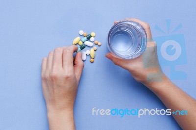 Taking Pill With Hand Holding Glass Of Water Stock Photo