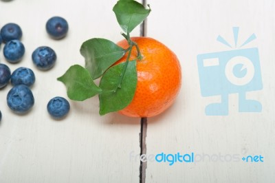 Tangerine And Blueberry On White Table Stock Photo