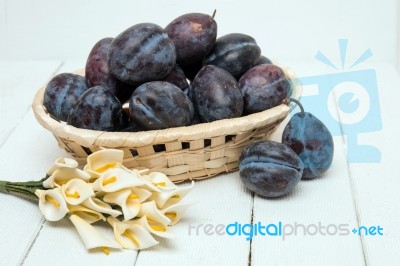 Tasty Purple Plums Isolated On A White Wooden Background Stock Photo