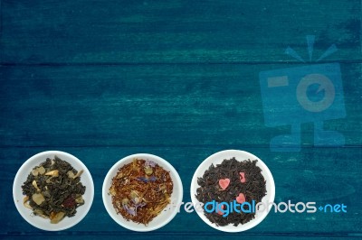 Tea Blendss On Strands In Presenters On Blue Wooden Background Stock Photo