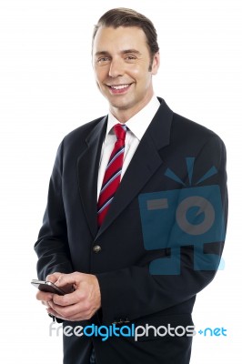 Team Leader Sending Text Message To His Colleagues Stock Photo