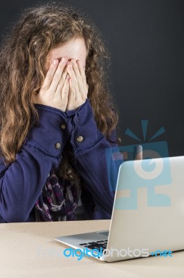 Teen Sitting At Table With A Laptop Stock Photo