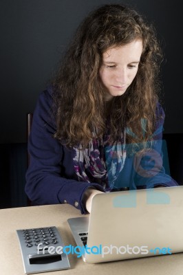 Teen Sitting At Table With A Laptop Stock Photo