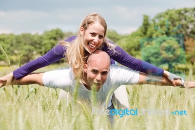 Teenage Couple With The Lady Piggybacking On Handsome Young Man Stock Photo