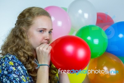 Teenage Girl Blowing Inflating Colored Balloons Stock Photo