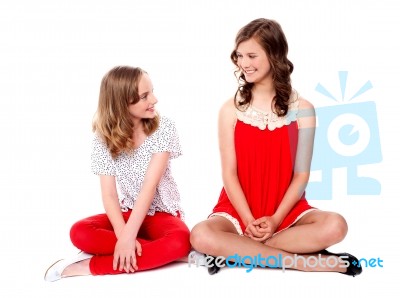 Teenage Sisters Sitting On Floor Stock Photo