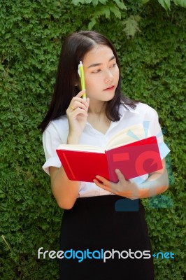 Thai Adult Student University Beautiful Girl Reading Red Book Stock Photo