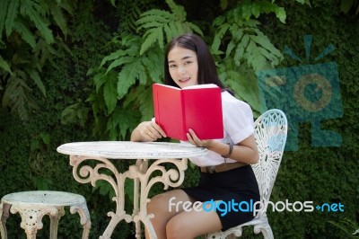 Thai Adult Student University Beautiful Girl Reading Red Book Stock Photo