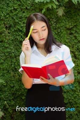 Thai Adult Student University Beautiful Girl Reading Red Book Stock Photo