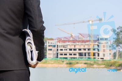 The Arms Of A Male Businessman Holding A Blueprint Stock Photo