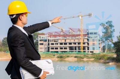 The Arms Of A Male Businessman Holding A Blueprint And Pointing Stock Photo