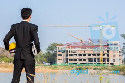 The Arms Of A Male Businessman Holding A Helmet And A Blueprint Stock Photo