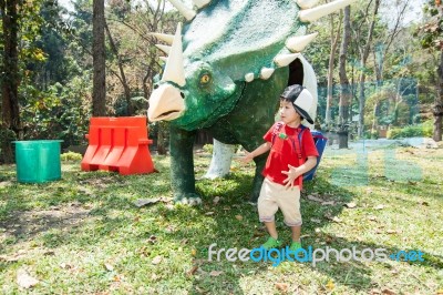 The Boy Is Walking Around Dinosaur Statue Stock Photo