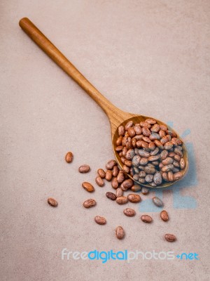 The Composition Of Raw Pinto Beans In Wooden Spoon On Brown Back… Stock Photo