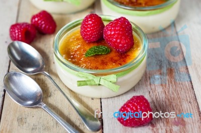 The Creme Brulee In Glass Dish With Mint And Raspberries Stock Photo