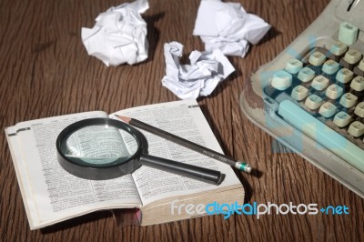 The Dictionary Consider Under A Magnifier On Writer's Desk Stock Photo