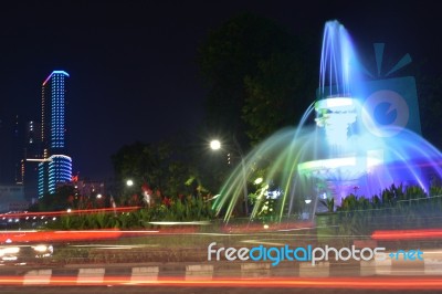 The Fountain At The City Intersection With The Building's Background Towering High Behind Stock Photo