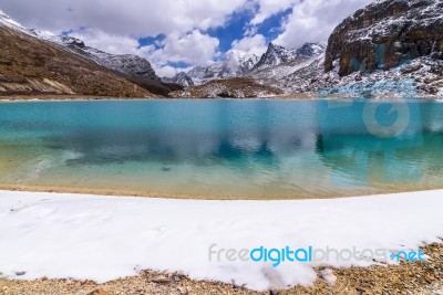 The Green Milk Lake Is Surrounded By Snow On The Mountains In Yading Nature Reserve Stock Photo