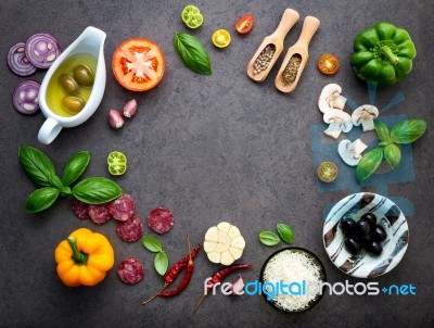 The Ingredients For Homemade Pizza On Dark Stone Background Stock Photo