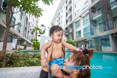 The Kid And Mom Play Together In The Pool Stock Photo