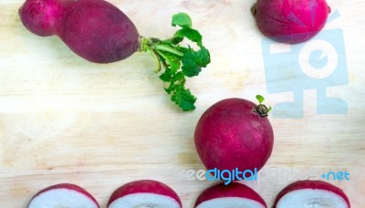 The Radishes On The Wooden Background Stock Photo