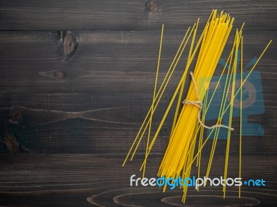 The Thin Spaghetti On Black Wooden Background. Yellow Italian Pa… Stock Photo