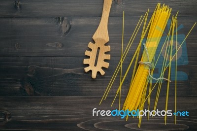 The Thin Spaghetti On Black Wooden Background. Yellow Italian Pa… Stock Photo