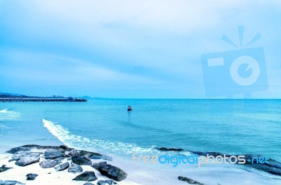 The View Of The Sand Beach And Sea Wave With Rock And Reef On Morning With Sunrise Stock Photo