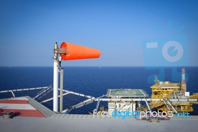 The Wind Sock Is Set On The Oil Rig To Showing Wind Direction Fo… Stock Photo