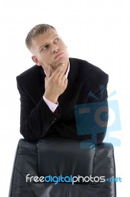 Thinking Businessman leant on Chair Stock Photo