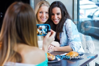 Three Friends Taking Photos With A Smartphone Stock Photo