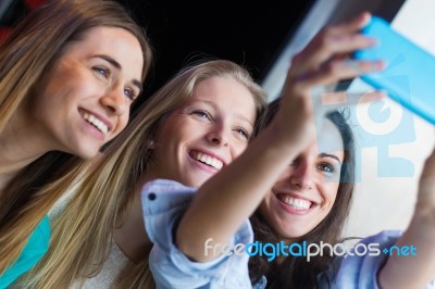 Three Friends Taking Photos With A Smartphone Stock Photo