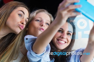 Three Friends Taking Photos With A Smartphone Stock Photo