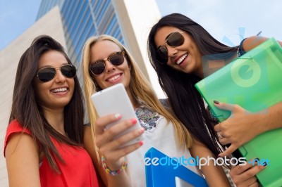 Three Girls Chatting With Their Smartphones At The Campus Stock Photo