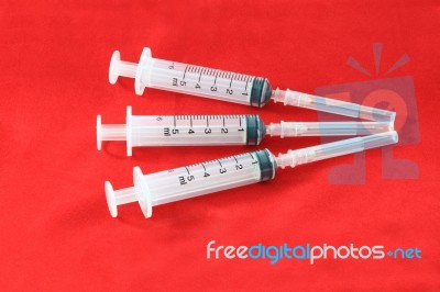 Three Hypodermic Syringe On Red Velvet For First Aid Kids Stock Photo