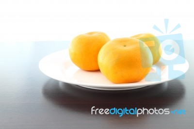 Three Orange Dish On Wooden Table Stock Photo