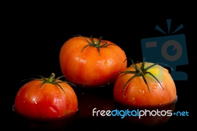 Three Red Tomatoes On A Black Background Stock Photo