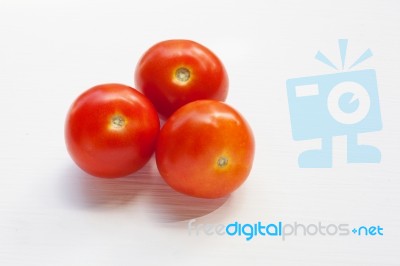 Three Red  Tomatoes On A White  Stock Photo