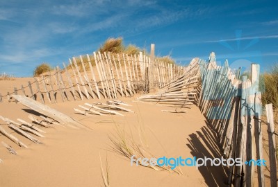 Three Rows Of Broken Fence On Sand Dunes Horizontal Wide Stock Photo