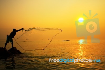 Throwing Fishing Net During Sunrise Stock Photo