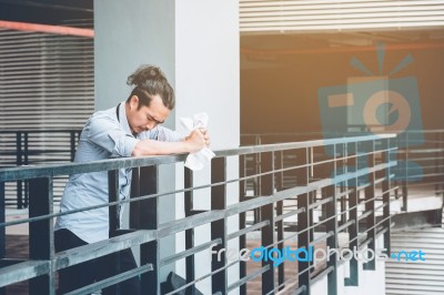 Tired Or Stressed Businessman Standing On The Walkway After Work… Stock Photo