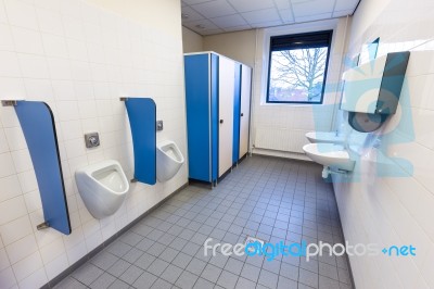 Toilet Room For Men With Urinals Sinks And Towel Dispenser Stock Photo