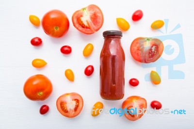 Tomatoes Juice In Bottle And Fresh Tomatoes Slices On White Wood… Stock Photo