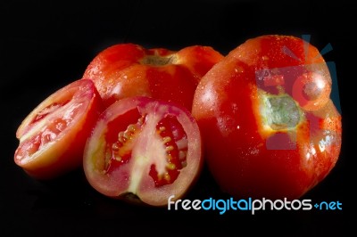 Tomatoes On Black Stock Photo