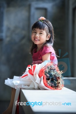 Toothy Smiling Face Of Asian Kid Happiness Emotion And Dry Flowers Bouquet Beside Stock Photo