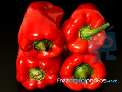 Top View Of Wet Red Peppers On Black Background Stock Photo