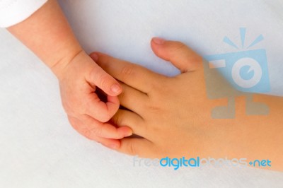 Touching Hands Of Little Girl And Baby Stock Photo