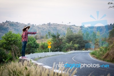 Tourist Hitchhiking Woman Standing On The Road In The Mountains Stock Photo