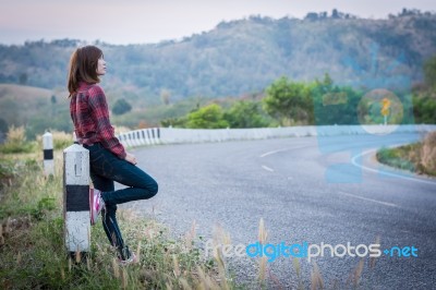 Tourist Hitchhiking Woman Standing On The Road In The Mountains Stock Photo