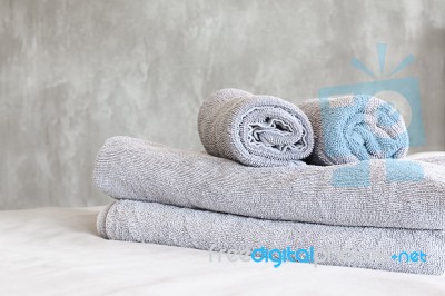 Towels On Bed And Stucco Wall Stock Photo